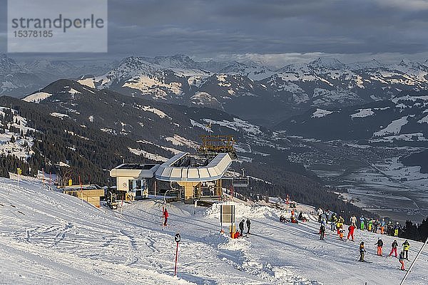 Skifahrer an der Bergstation  Kälberalmbahn  hinter der Alpenkette  SkiWelt Wilder Kaiser  Brixen im Thale  Tirol  Österreich  Europa