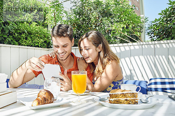Fröhliches junges Paar nimmt Tabletten zum Frühstück