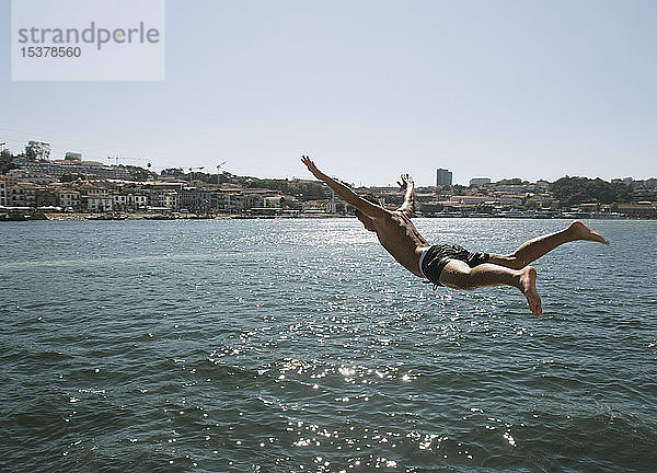 Junger Mann springt ins Wasser  Porto  Portugal