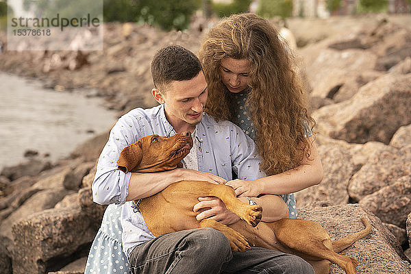 Junges Paar mit Hund am Strand