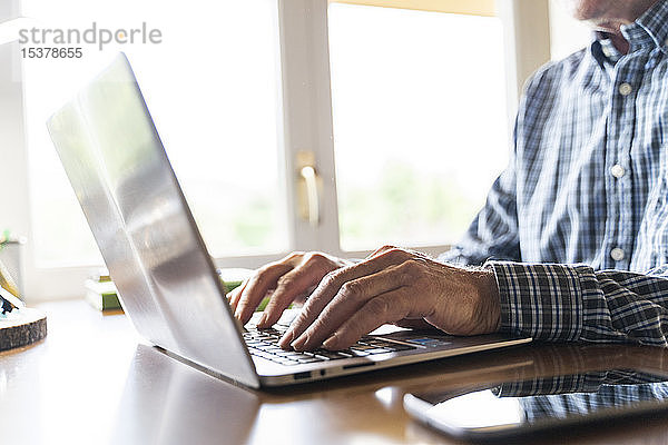 Älterer Mann benutzt Laptop zu Hause