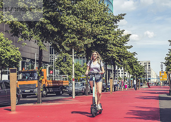 Junge Frau fährt E-Scooter auf dem Boulevard of the Stars  Berlin  Deutschland