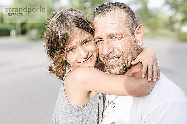 Vater und Tochter umarmen sich im Freien