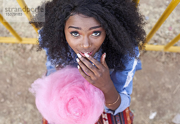 Porträt einer jungen Frau mit rosa Zuckerwatte