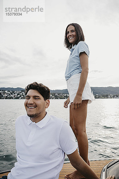 Glückliches junges Paar bei einer Bootsfahrt auf einem See