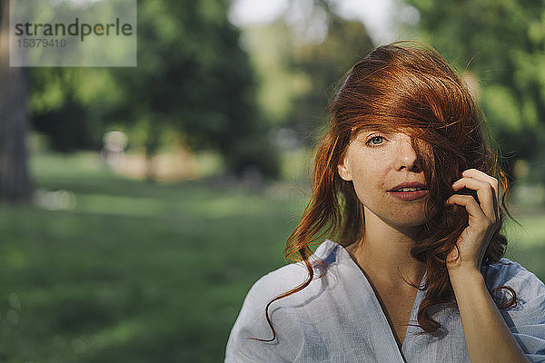 Porträt einer schönen rothaarigen Frau in einem Park
