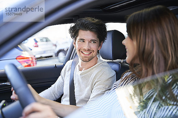 Glückliches Paar im Auto mit Frau am Steuer