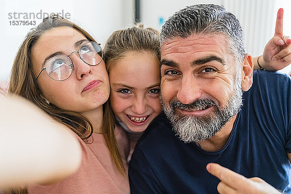 Selfie eines glücklichen Vaters mit zwei Töchtern
