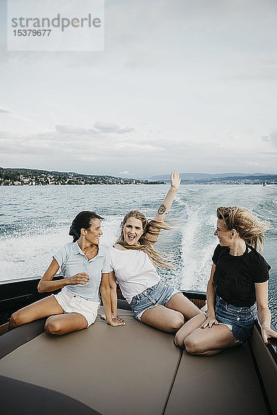 Glückliche Freundinnen haben Spaß bei einer Bootsfahrt auf einem See