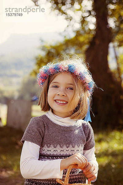 Bildnis eines lächelnden jungen Mädchens mit Haarkranz im Freien