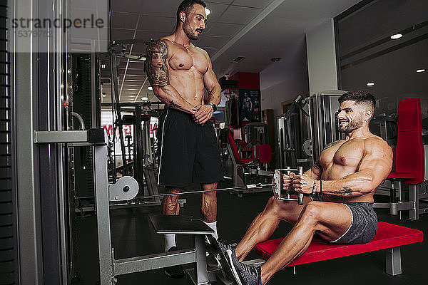 Muskulöse Männer trainieren im Fitnessstudio