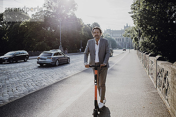 Geschäftsmann mit E-Scooter in der Stadt