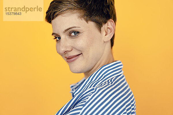 Porträt einer lächelnden Frau mit orangem Hintergrund