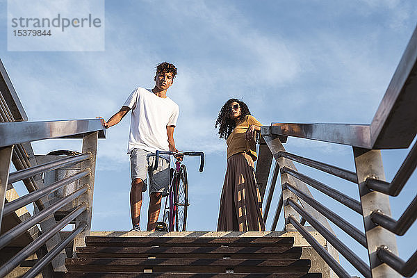 Junges Paar mit Fahrrad  stehend auf einer Treppe