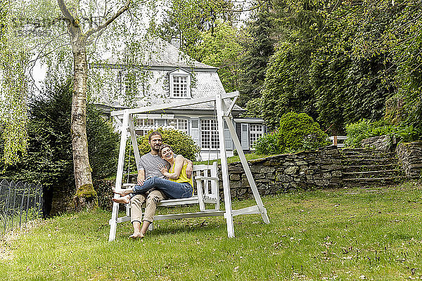 Entspanntes Paar im Garten seines Hauses