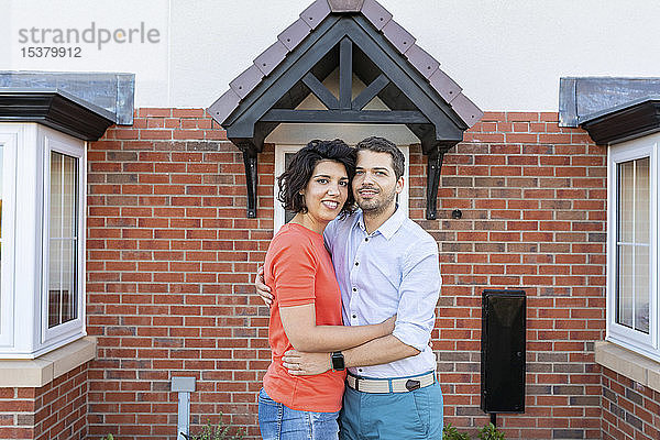 Porträt eines glücklichen Paares vor ihrem neuen Zuhause