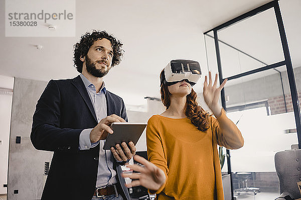 Geschäftsmann und Geschäftsfrau mit VR-Brille und Tablett im Büro