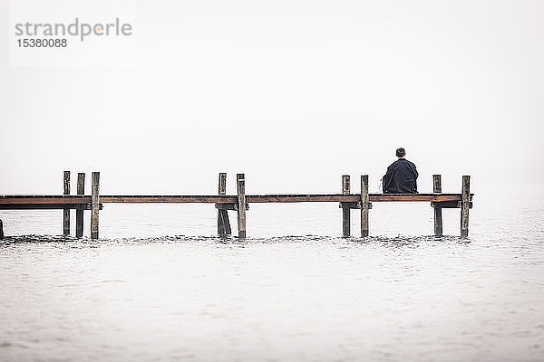 Rückenansicht eines Mannes auf dem Steg am Starnberger See  Deutschland