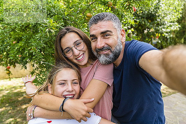 Glücklicher Vater mit zwei Töchtern  die Selbsthilfe im Garten betreiben