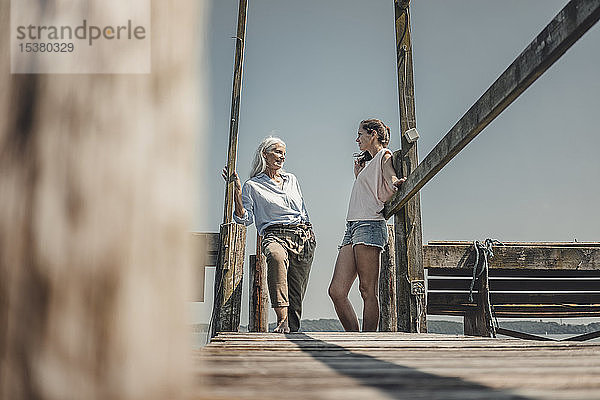 Mutter und Tochter stehen am Steg und verbringen einen Tag am Meer