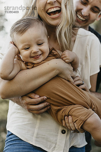 Glückliche Mutter umarmt ihren kleinen Sohn im Freien