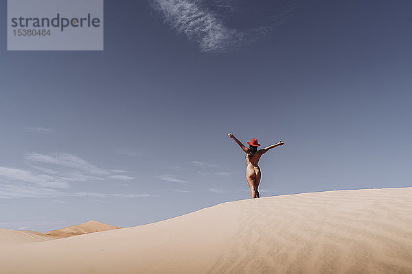 Nackte junge Frau mit Hut in der Wüste  Merzouga  Marokko