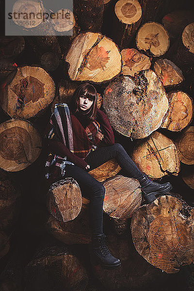 Porträt einer jungen Frau am Holzstapel