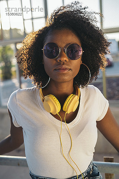 Porträt einer jungen Frau mit Sonnenbrille und Kopfhörer