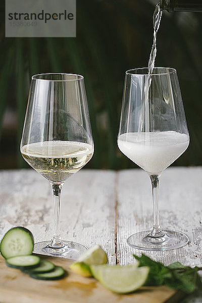 Nahaufnahme eines Cocktails  der im Glas auf einem Holztisch ausgeschenkt wird