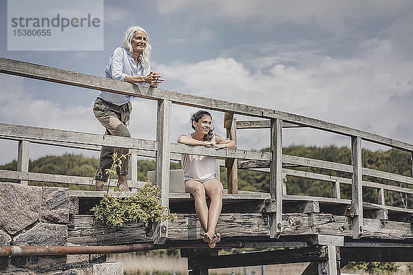 Mutter und Tochter beim Blick von einer Brücke