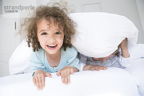 Porträt eines glücklichen Jungen mit seinem Bruder im Bett