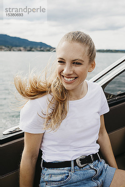 Glückliche junge Frau bei einer Bootsfahrt auf einem See