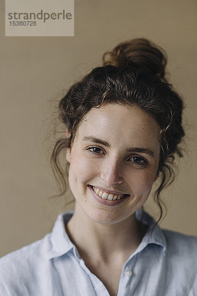 Porträt einer lächelnden jungen Frau mit Brötchen