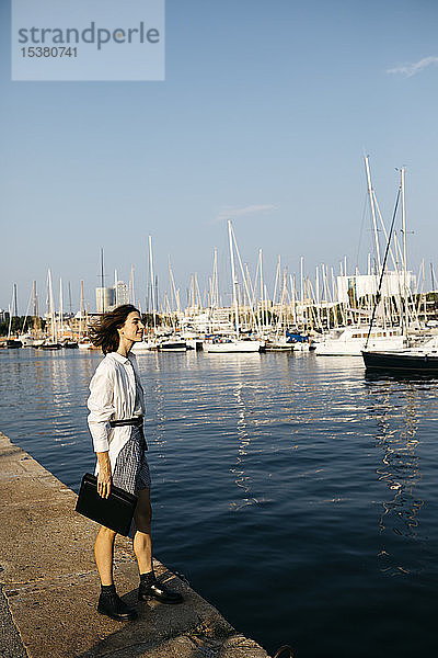 Hübsche Geschäftsfrau am Jachthafen  die nach der Arbeit Boote beobachtet