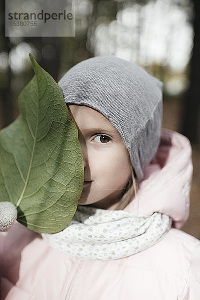 Bildnis eines kleinen Mädchens mit großem grünen Blatt