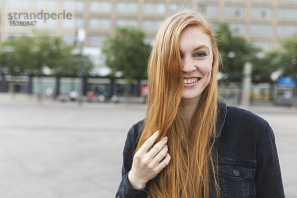 Porträt einer rothaarigen jungen Frau auf dem Alexanderplatz  Berlin  Deutschland
