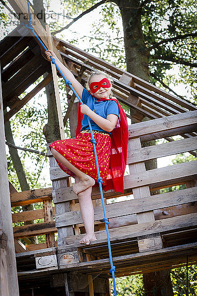 Superheldin spielt in einem Baumhaus