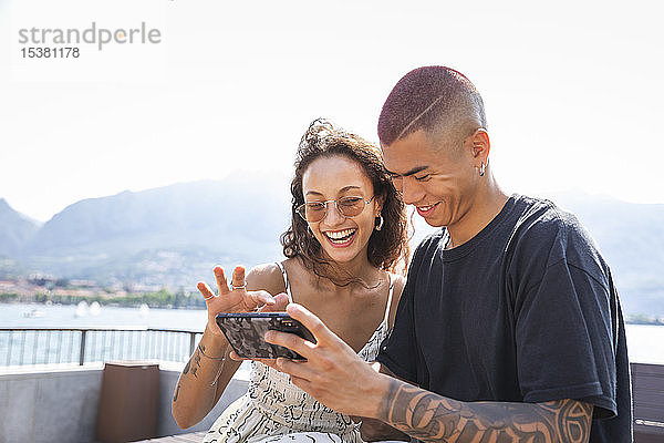 Glückliches junges Paar schaut auf Handy  Lecco  Italien