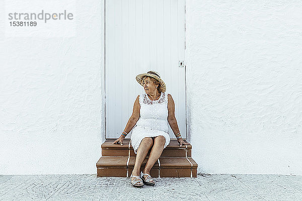Älterer Tourist sitzt in einem Dorf auf der Treppe  El Roc de Sant Gaieta  Spanien