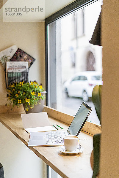 Laptop auf dem Tisch am Fenster in einem Cafe