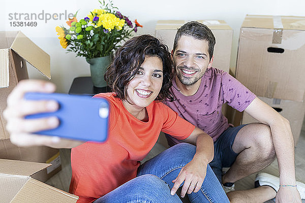 Glückliches Paar  das sich im neuen Zuhause ein Selfie gönnt