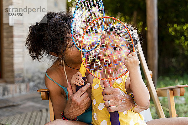 Großmutter spielt mit kleinen Mädchen und Badmintonschlägern im Freien