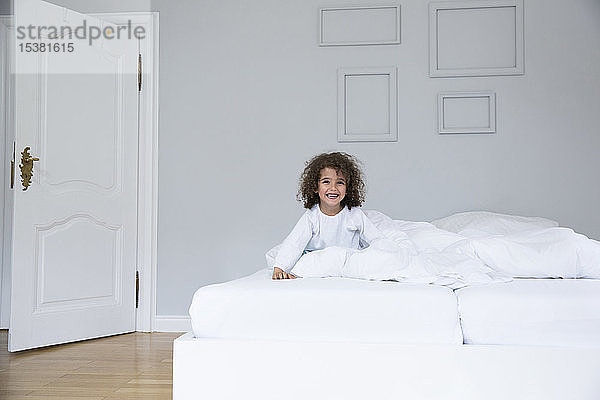 Porträt eines süßen  glücklichen Jungen im Bett
