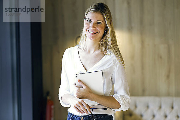 Porträt einer lächelnden Geschäftsfrau  die ein Tablett hält