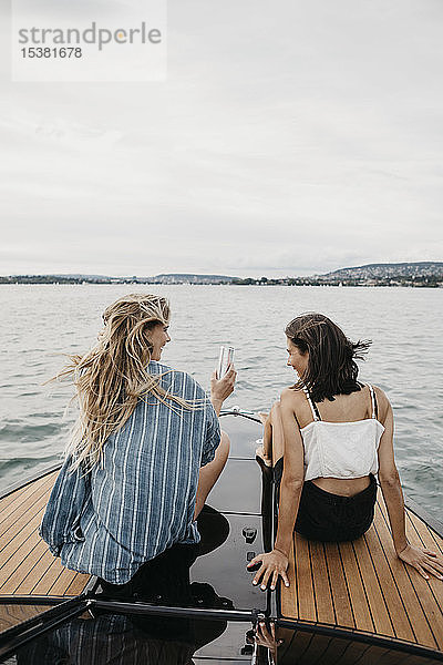 Glückliche Freundinnen bei einer Bootsfahrt auf einem See