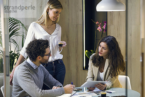 Drei Geschäftsleute bei einer Besprechung in einem modernen Büro