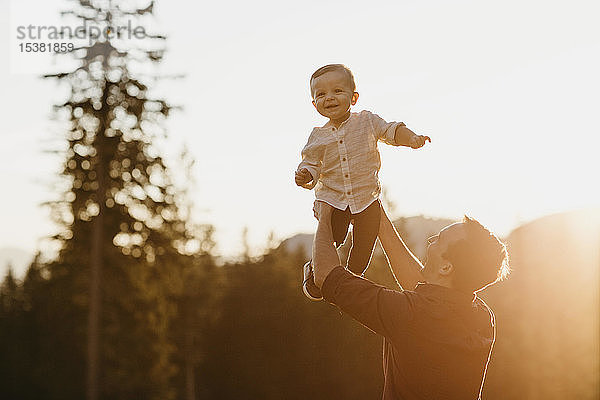 Glücklicher Vater erhebt kleinen Sohn bei Sonnenuntergang im Freien  Schwaegalp  Nesslau  Schweiz
