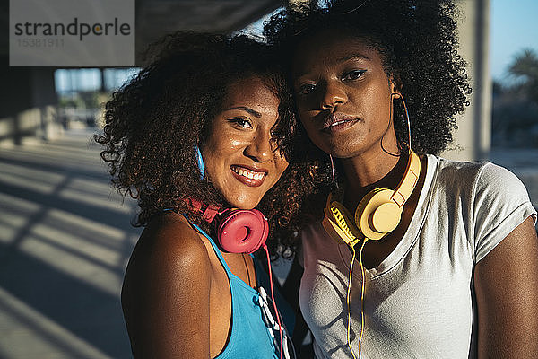 Porträt von zwei jungen Frauen mit Kopfhörern