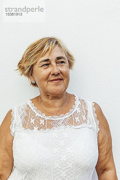 Porträt einer älteren Frau mit weißem Wandhintergrund