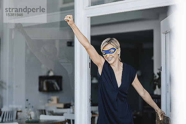 Geschäftsfrau mit Superhelden-Masken  die vorgibt zu fliegen